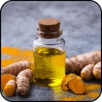 Turmeric root and a bottle of turmeric oil